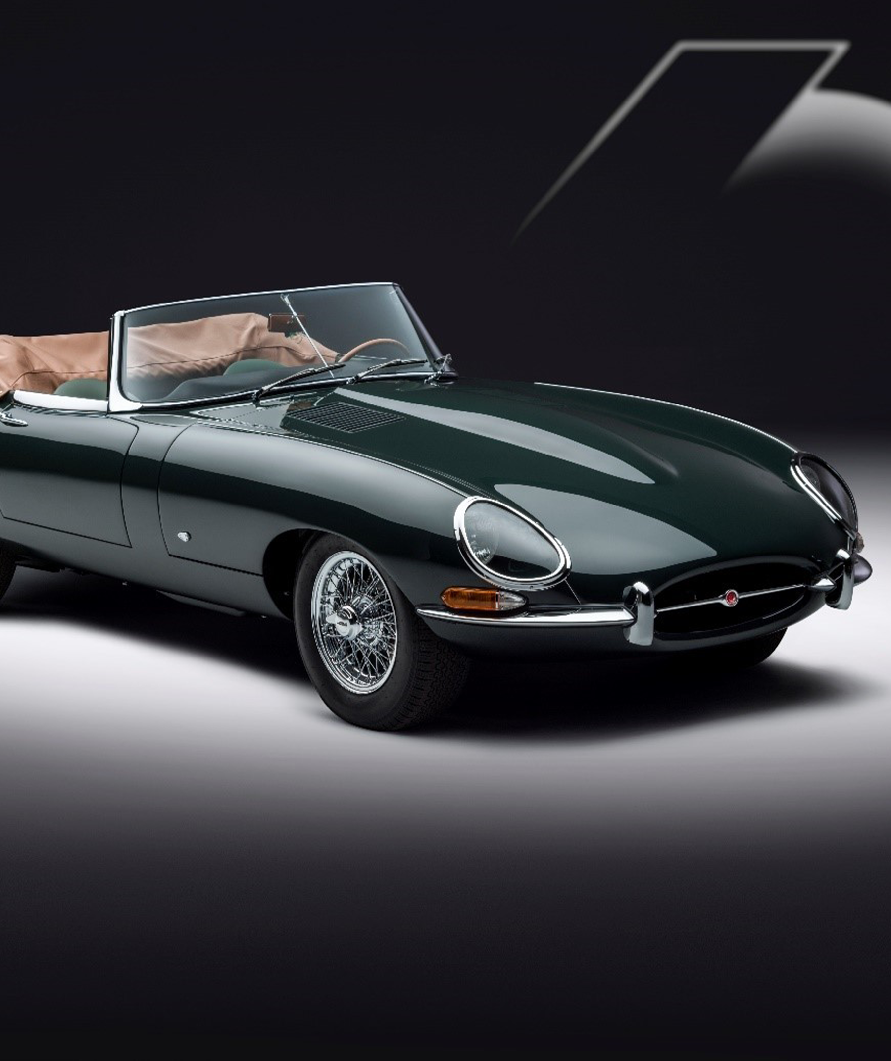 Dark green convertible E-Type with chrome accents and tan interior.