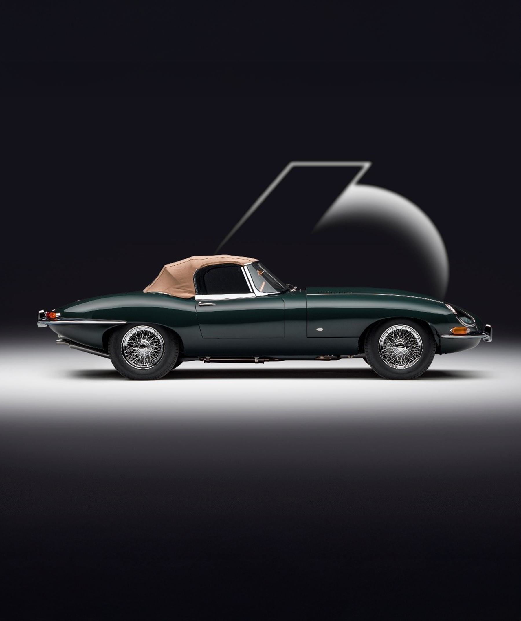 Dark green classic convertible E-Type with beige soft top, side view, against a stylised number 60.