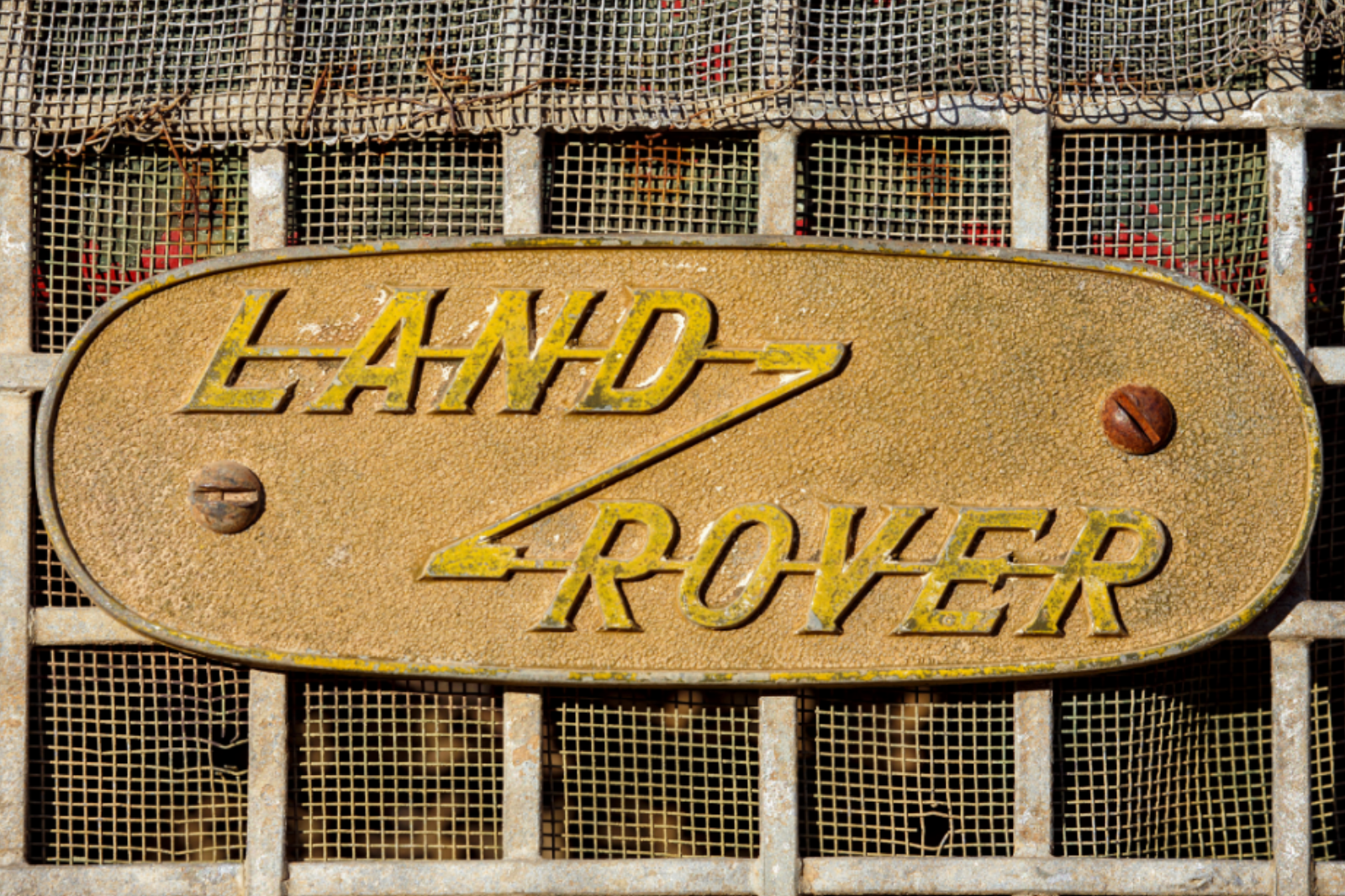 Close-up of Land Rover grille with oval 'LAND ROVER' badge.